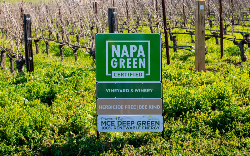 Napa Green certified sign featuring sub-signs "vineyards & winery" "herbicide free | bee kind" "MCE Deep Green 100% Renewable Energy"